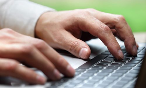 Hands typing on laptop computer